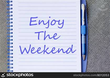 Enjoy the weekend text concept write on notebook