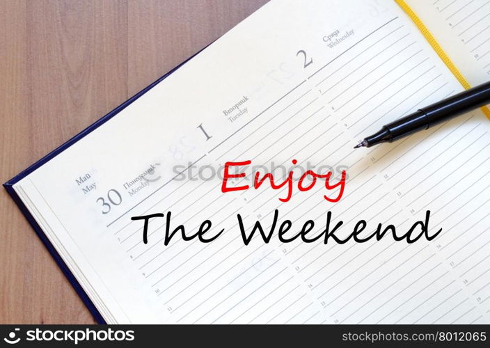 Enjoy the weekend text concept write on notebook