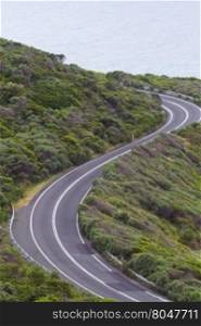 Enjoyable curves of Great Ocean Road in Victoria province of Australia. Scenic drive along the Surf Coast with its sea views is a popular tourist attraction. Vertical image with copy space.