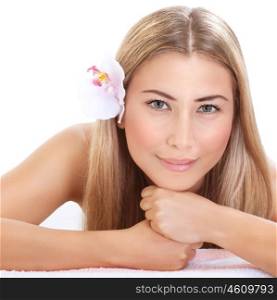 Enjoying dayspa, closeup portrait of beautiful girl with orchid flower in hair isolated on white background, laying down, luxury spa salon