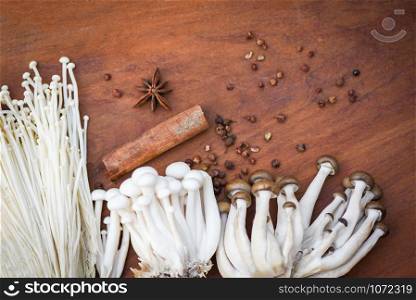 Enoki or Golden Needle Mushroom and Shimeji Mushroom with herbs and spices on wooden background