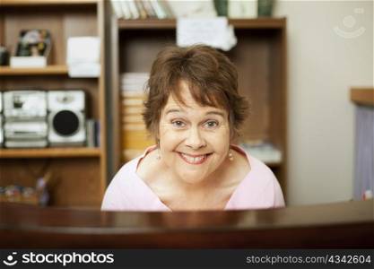 Enthusiastic store clerk or office worker behind her desk.