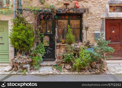 Entrance of the old village house decorated with flowers and old things, Provence France