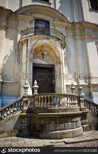 entrance to ancient church with cross over door