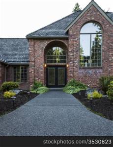 Entrance to front door of upscale home with trees and sky in background