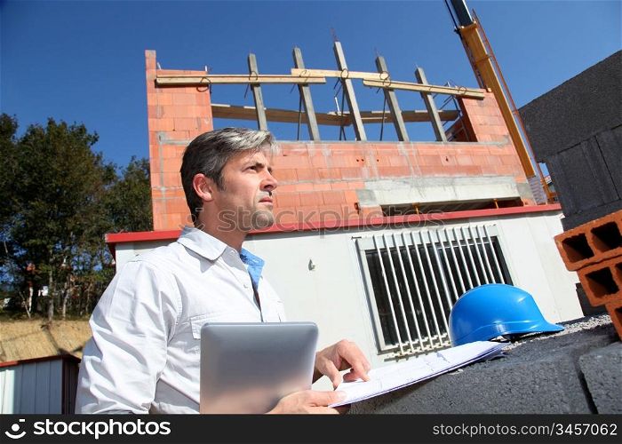 Entrepreneur checking plan on construction site