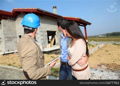 Entrepreneur showing house under construction to couple