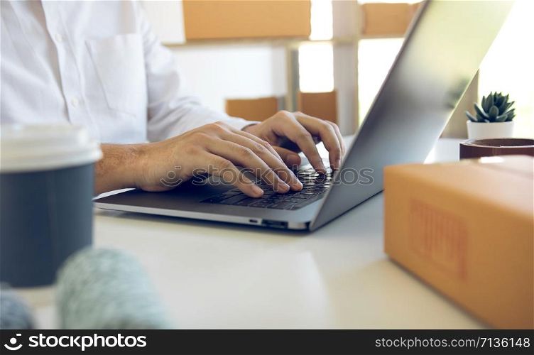 Entrepreneurs are working on taking orders of customers products by typing information tpying keyboard laptop computer in office room.