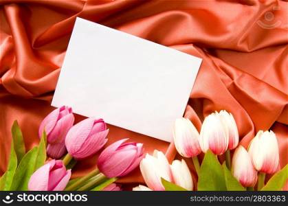 Envelope and flowers on the satin background