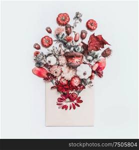 Envelope with autumn floral arrangement on white desk background. Creative fall ideas. Blog layout. Autumn objects of nature. Top view. Flat lay