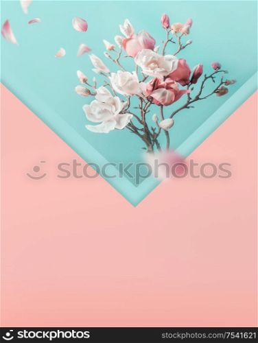 Envelope with pink white spring blossom branches and flying petals. Creative spring time layout in pastel color. Spring holidays concept. Magnolia blooming