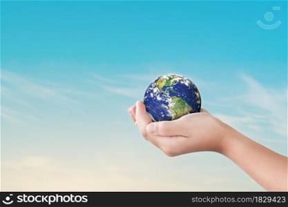 Environment day concept, Globe in child hands over blue sky background. Save of earth. Elements of this image furnished by NASA