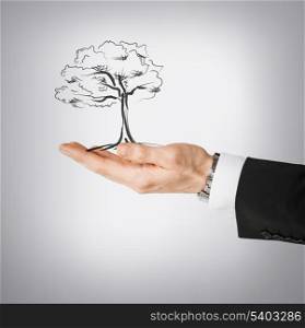 environment, ecology and nature protection concept - man with small tree in his hand