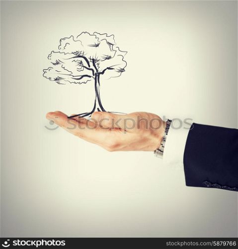 environment, ecology and nature protection concept - man with small tree in his hand