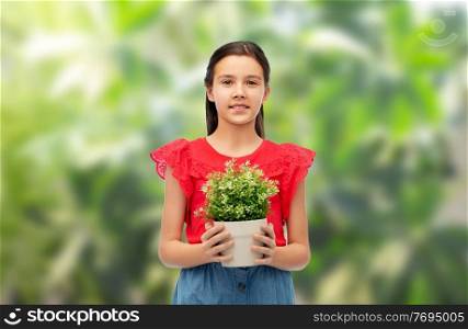environment, nature and people concept - happy smiling girl holding flower in pot over green natural background. happy smiling girl holding green flower in pot