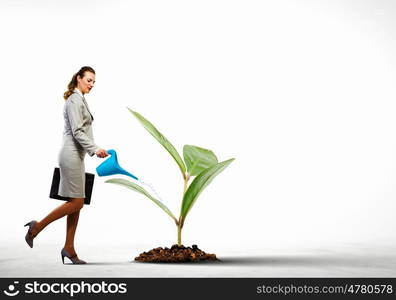 Environment protection. Image of businesswoman watering tree with pot. Ecology concept