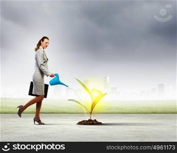 Environment protection. Image of businesswoman watering tree with pot. Ecology concept