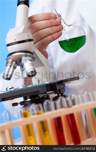 Environmental concept shot showing a medical or scientific researcher using a microscope working in a laboratory and coming up with a green solution