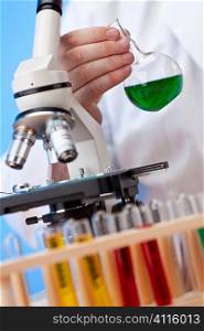 Environmental concept shot showing a medical or scientific researcher using a microscope working in a laboratory and coming up with a green solution