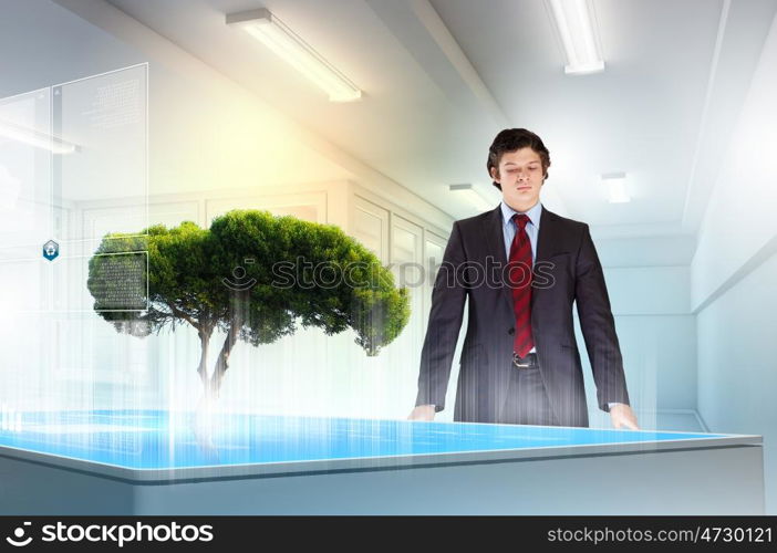 Environmental problems and high-tech innovations. Image of young businessman against high-tech picture of environment concept