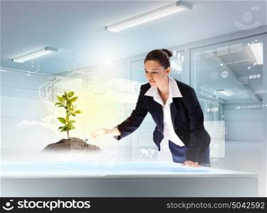 Environmental problems and high-tech innovations. Image of young businesswoman holding cup standing against high-tech picture
