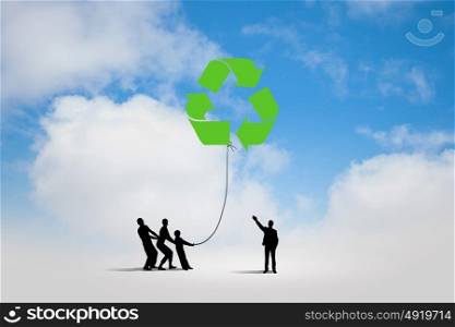Environmental protection. Silhouettes of people pulling balloon with recycle sign