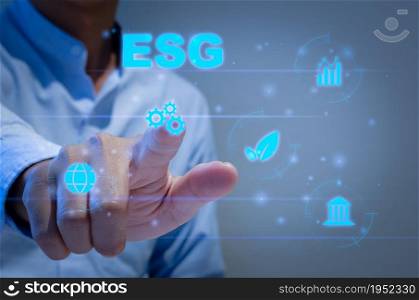 Environmental, social, and governance (ESG) investment Organizational growth that is sustainable is a business idea. A man&rsquo;s hand touches the ESG word on a virtual screen.