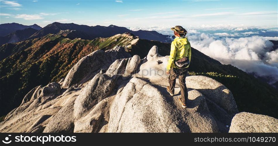 Epic adventure of hiker do trekking activity in mountain of Northern Japan Alps, Nagano, Japan, with panoramic nature mountain range landscape. Motivation leisure sport and discovery travel concept.