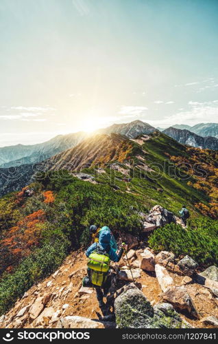 Epic adventure of hiker do trekking activity in mountain of Northern Japan Alps, Nagano, Japan, with panoramic nature mountain range landscape. Motivation leisure sport and discovery travel concept.