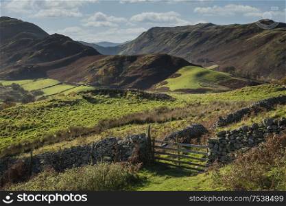 Epic Autumn Fall landscape image of Sleet Fell and Howstead Brow in Lake District with beautiful early morning light in valleys and on hills