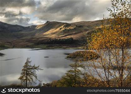 Epic Autumn Fall landscape of Hawes Water with epic lighting and dramatic sunlight in Lake District