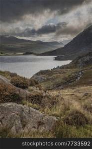 Epic early Autumn Fall landscape of view along Ogwen Valley with Llyn Ogwen and Tryfan under moody evening sky with copy space