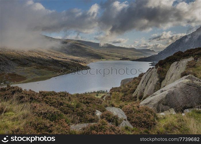 Epic early Autumn Fall landscape of view along Ogwen Valley with Llyn Ogwen and Tryfan under moody evening sky with copy space