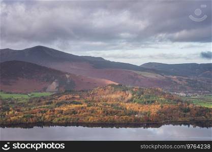Epic landscape Autumn image of view from Walla Crag in Lake District, over Derwentwater looking towards Catbells and distant mountains with stunning Fall colors and light