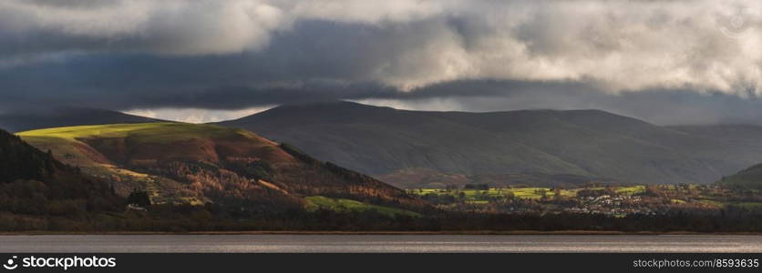 Epic landscape image across Bassenthwaite Lake in Lake District suring dramatic Autumn evening