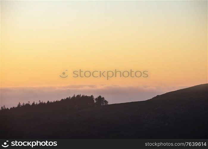 Epic landscape image at sunset over Dartmoor National Park in Engand with beautiful soft pastel colors