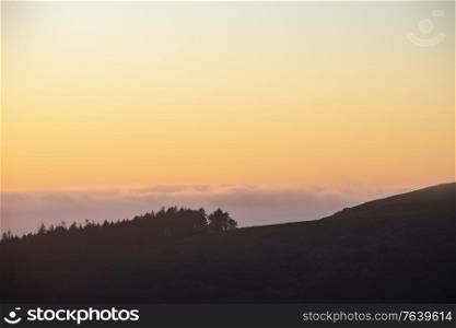 Epic landscape image at sunset over Dartmoor National Park in Engand with beautiful soft pastel colors