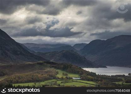 Epic sun beams light up Crummock Water in dramatic Autumn Fall landscape image with Mellbreak and Grasmoor