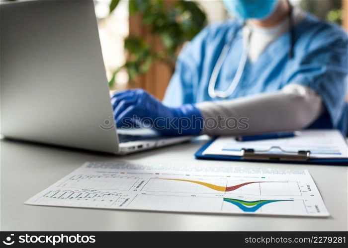 Epidemiologist doctor working on laptop computer,analyzing graphs   charts,COVID-19 Coronavirus global pandemic crisis outbreak,mortality rate death toll statistics,research   data comparison,WHO info