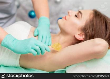 Epilation armpit of young woman by beautician close up.. Epilation armpit of woman