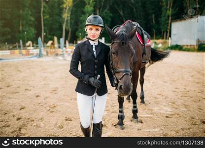 Equestrian sport, female jockey and horse. Brown stallion, horseback riding, leisure with animal. Equestrian sport, female jockey and horse