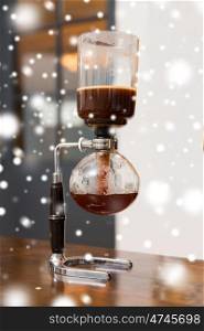 equipment and technology concept - close up of siphon vacuum coffee maker at shop over snow. close up of siphon vacuum coffee maker at shop