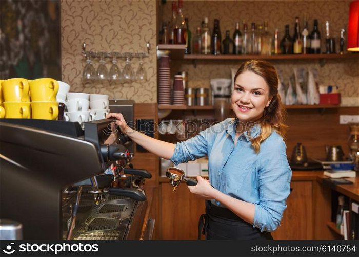 equipment, coffee shop, people and technology concept - barista woman making coffee by machine at cafe bar or restaurant kitchen