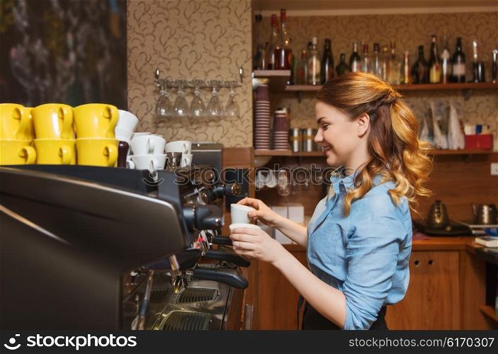 equipment, coffee shop, people and technology concept - barista woman making coffee by espresso machine at cafe bar or restaurant kitchen