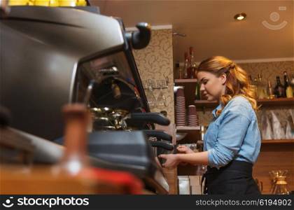 equipment, coffee shop, people and technology concept - barista woman making coffee by machine at cafe bar or restaurant kitchen