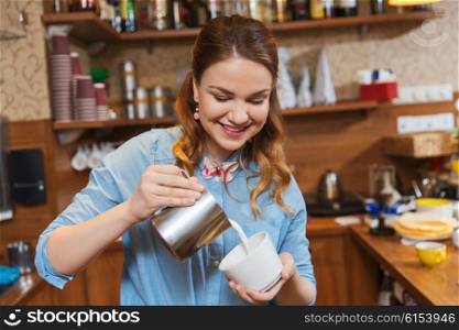 equipment, coffee shop, people and technology concept - barista woman pouring cream to cup of coffee at cafe bar or restaurant kitchen