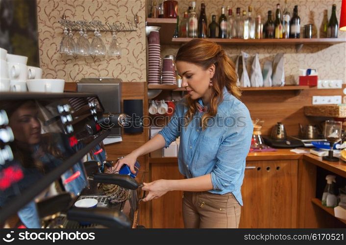 equipment, coffee shop, people and technology concept - barista woman pouring cream to jug at coffee machine