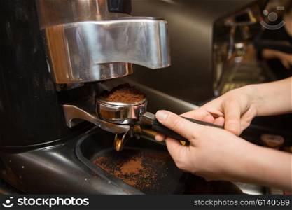 equipment, coffee shop, people and technology concept - close up of woman making coffee by machine at cafe bar or restaurant kitchen