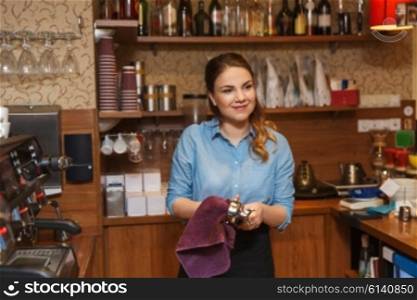 equipment, coffee shop, people and technology concept - happy barista woman cleaning espresso machine holder at restaurant bar