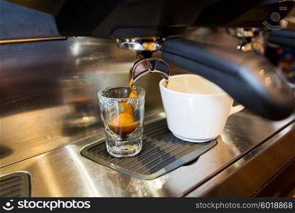 equipment, drinks and technology concept - close up of espresso machine making coffee